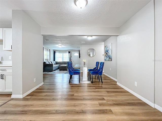 interior space featuring a textured ceiling and light hardwood / wood-style flooring