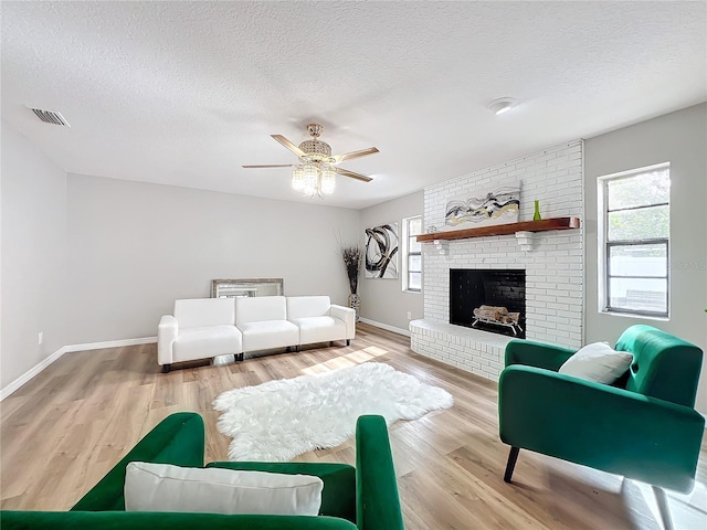 living room featuring a wealth of natural light, a textured ceiling, and light wood-type flooring