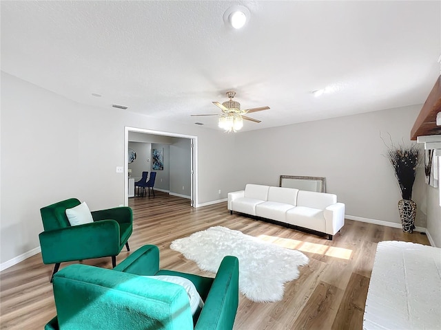 living room with light hardwood / wood-style flooring and ceiling fan