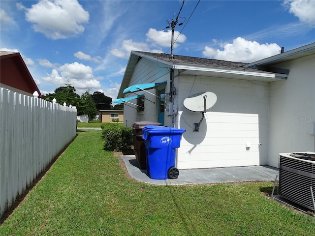 view of side of home featuring a yard and central AC unit