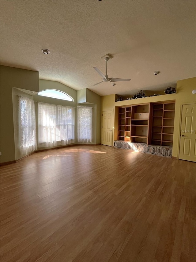 spare room featuring hardwood / wood-style flooring, lofted ceiling, a textured ceiling, and ceiling fan