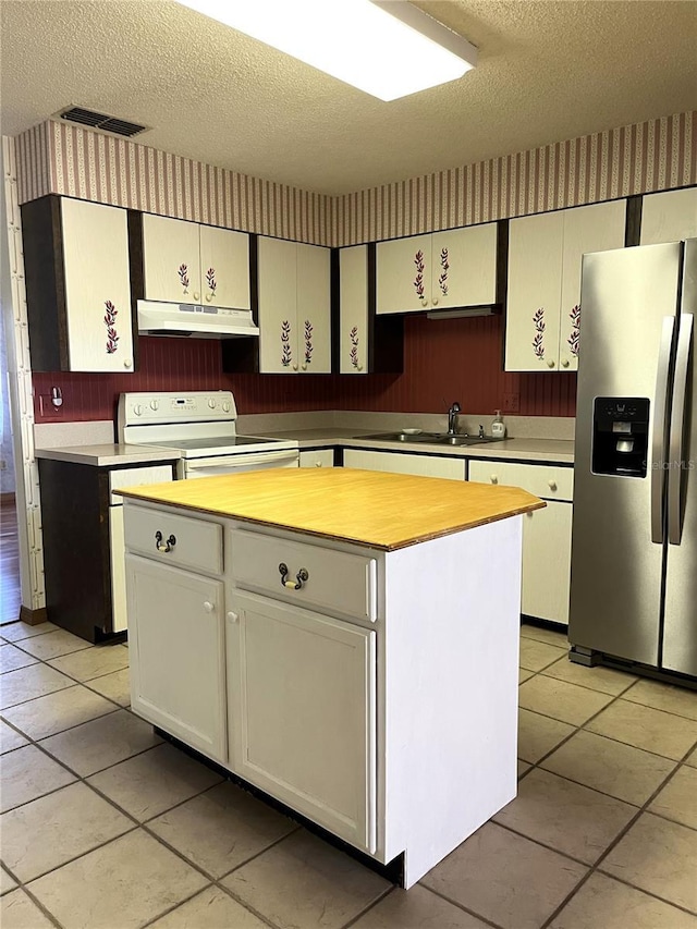 kitchen with sink, stainless steel fridge, a kitchen island, white range with electric stovetop, and white cabinets