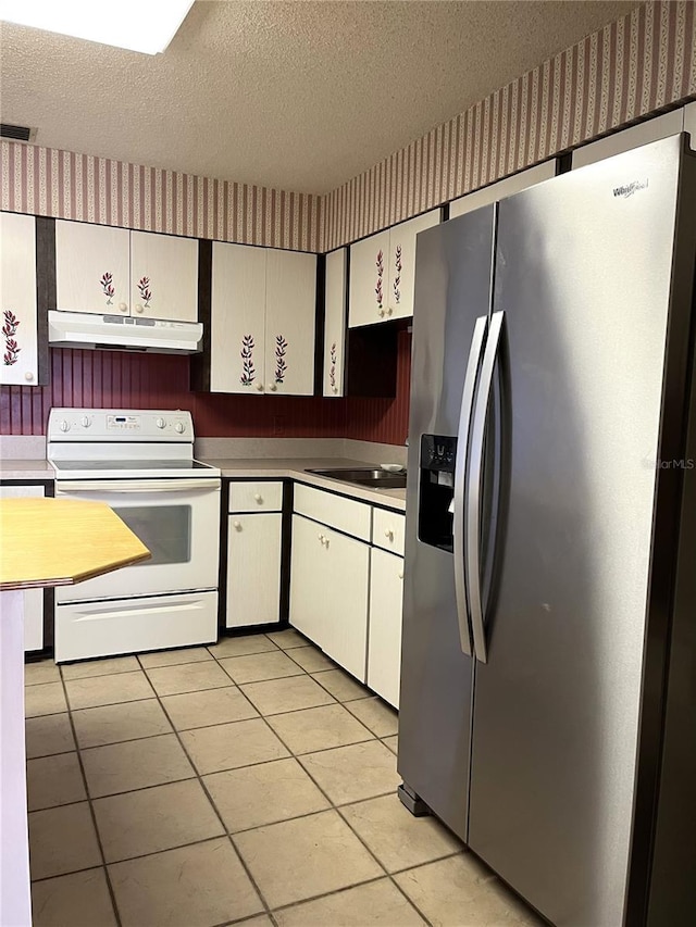 kitchen featuring white electric range oven, stainless steel fridge with ice dispenser, a textured ceiling, light tile patterned floors, and white cabinets