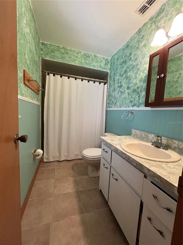 bathroom with tile patterned flooring, vanity, and toilet