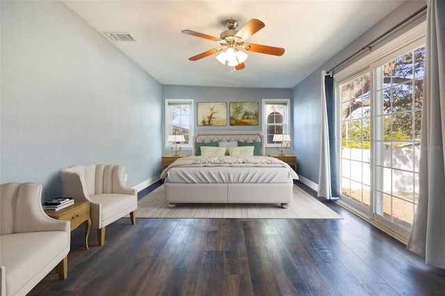 bedroom featuring dark wood-type flooring, ceiling fan, multiple windows, and access to outside