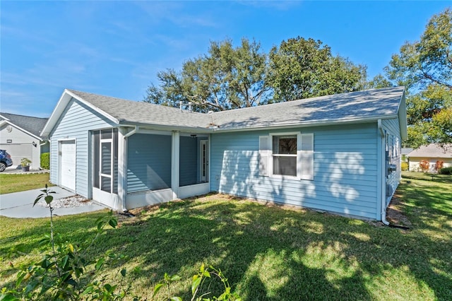 single story home with a garage, a front yard, and a sunroom