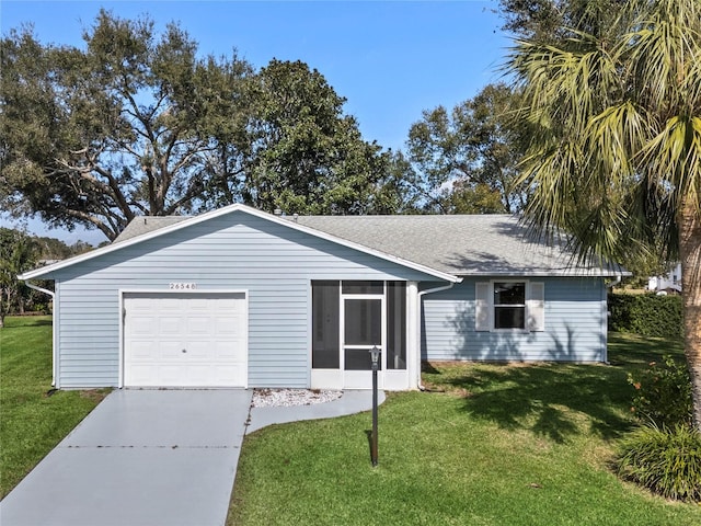 view of front of property with a garage, a sunroom, and a front yard