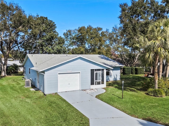 view of front of house featuring a garage, cooling unit, and a front lawn