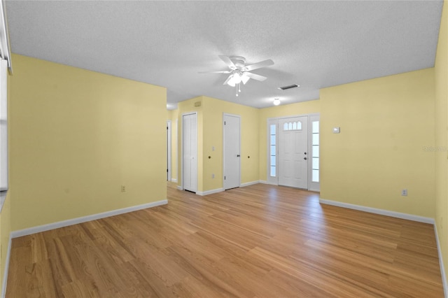 interior space featuring ceiling fan, a textured ceiling, and light hardwood / wood-style flooring