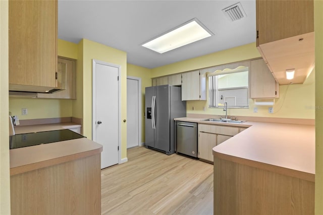 kitchen with stainless steel appliances, light brown cabinetry, sink, and light wood-type flooring