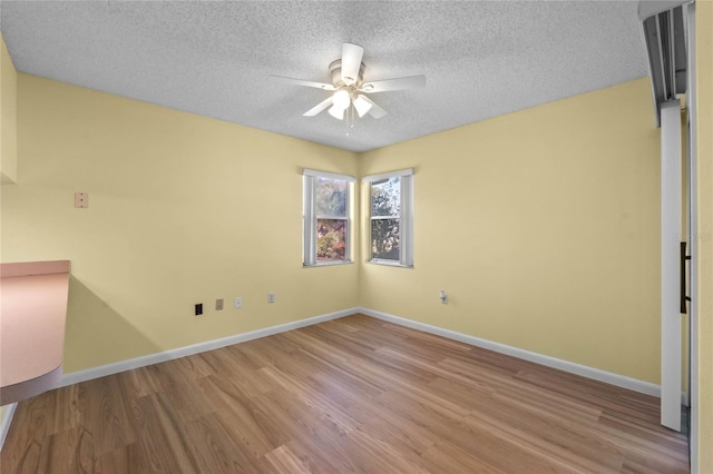 spare room featuring ceiling fan, a textured ceiling, and light wood-type flooring