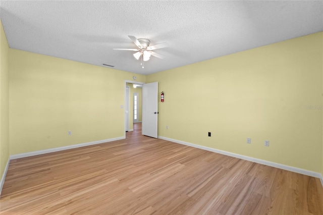 empty room featuring ceiling fan, a textured ceiling, and light wood-type flooring