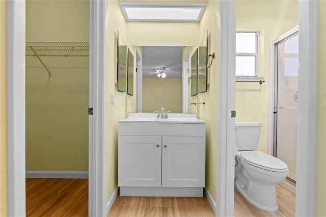 bathroom featuring hardwood / wood-style flooring, vanity, toilet, and a shower with shower door