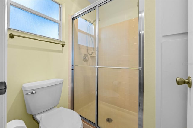 bathroom featuring an enclosed shower and toilet