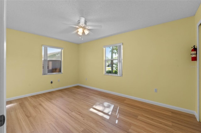 empty room featuring ceiling fan, light hardwood / wood-style floors, and a textured ceiling