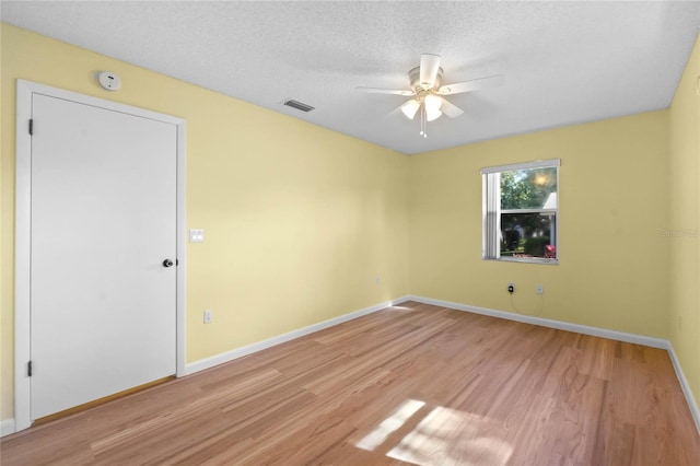 unfurnished room featuring ceiling fan, a textured ceiling, and light hardwood / wood-style flooring