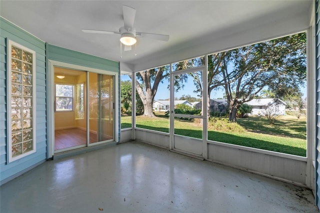 unfurnished sunroom featuring ceiling fan