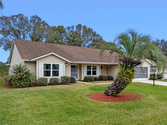 ranch-style home featuring a garage and a front lawn