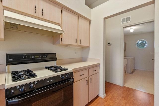 kitchen featuring black gas stove, light brown cabinetry, and light hardwood / wood-style floors