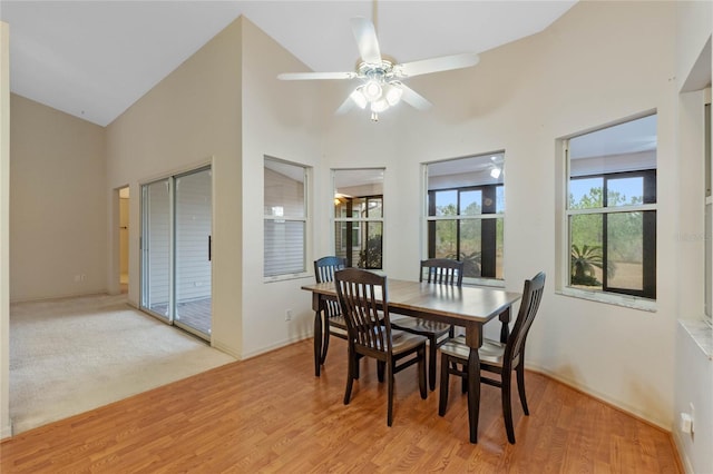 dining room with ceiling fan, light hardwood / wood-style flooring, and a high ceiling