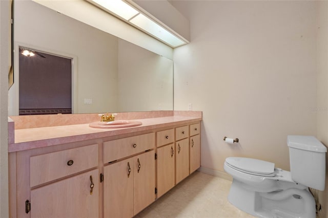 bathroom with vanity, a skylight, and toilet