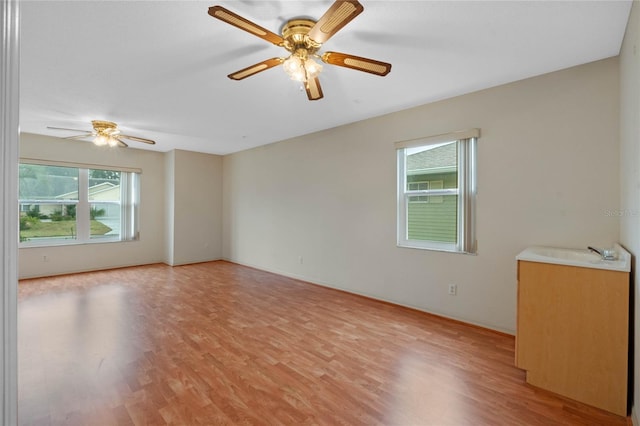 spare room featuring sink, ceiling fan, and light hardwood / wood-style flooring