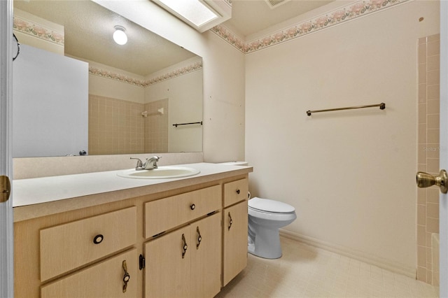 bathroom featuring vanity, toilet, and a tile shower