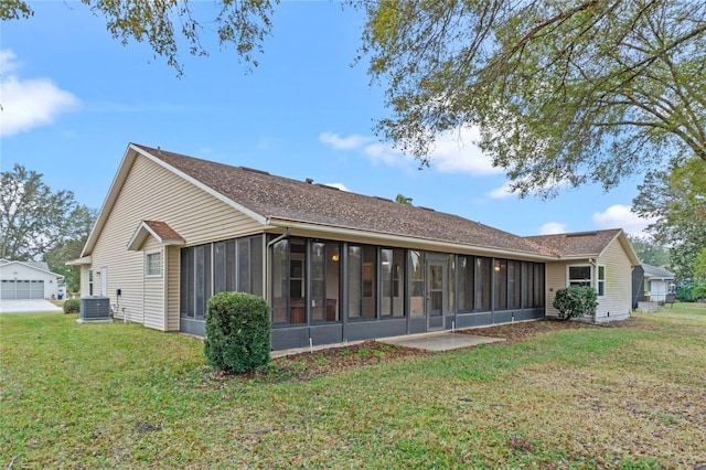 rear view of house featuring cooling unit, a yard, and a sunroom