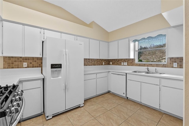 kitchen with sink, tasteful backsplash, vaulted ceiling, white appliances, and white cabinets