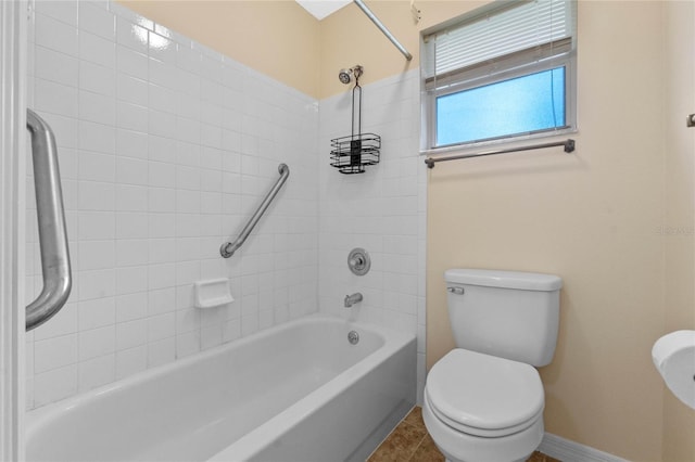 bathroom with tiled shower / bath combo, tile patterned floors, and toilet