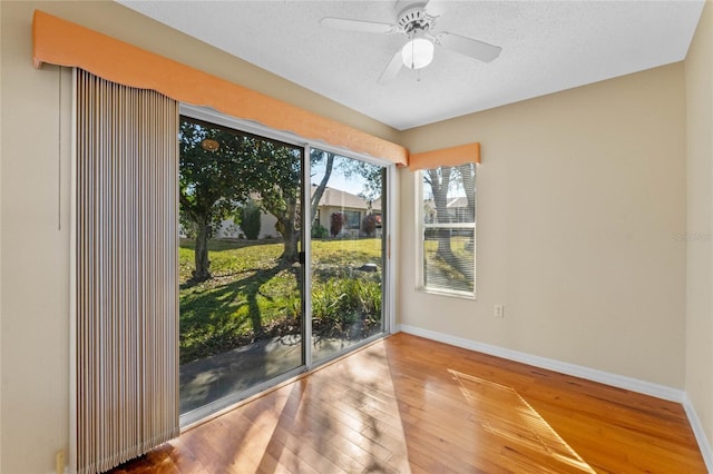 spare room with hardwood / wood-style flooring, ceiling fan, and a textured ceiling