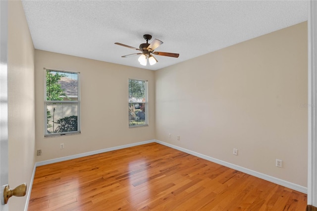 unfurnished room featuring ceiling fan, a textured ceiling, light hardwood / wood-style flooring, and a healthy amount of sunlight