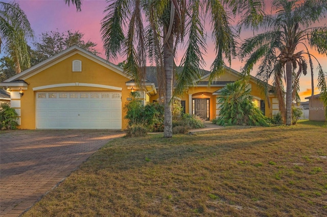 view of front of property featuring a garage and a lawn