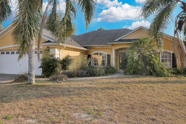 ranch-style house with a garage and a front lawn