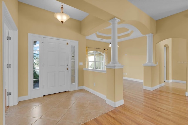 entryway with decorative columns and light hardwood / wood-style floors