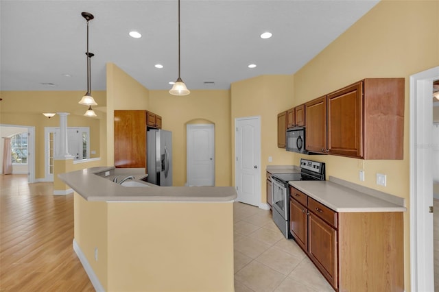 kitchen featuring sink, decorative light fixtures, a center island with sink, appliances with stainless steel finishes, and decorative columns