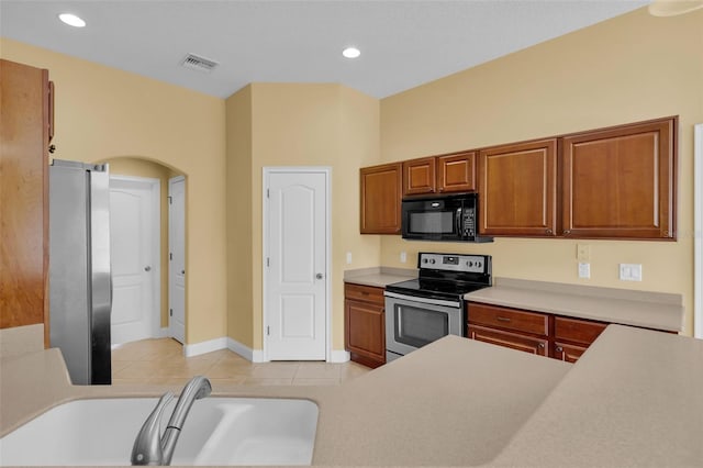 kitchen featuring light tile patterned flooring, stainless steel appliances, and sink