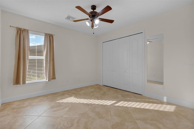 unfurnished bedroom featuring light tile patterned floors, a closet, and ceiling fan