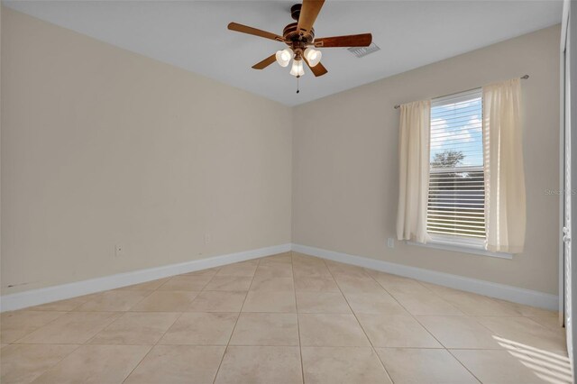 tiled spare room with ceiling fan