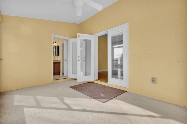 spare room featuring carpet, ceiling fan, and french doors