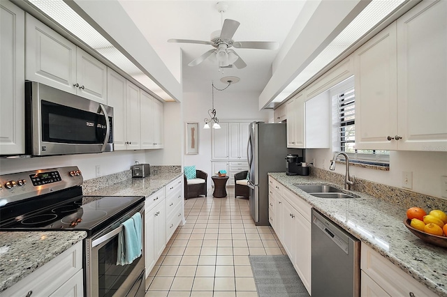 kitchen with stainless steel appliances, sink, light tile patterned floors, and light stone counters