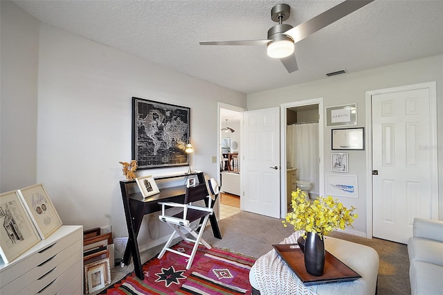 office space with ceiling fan, carpet, and a textured ceiling