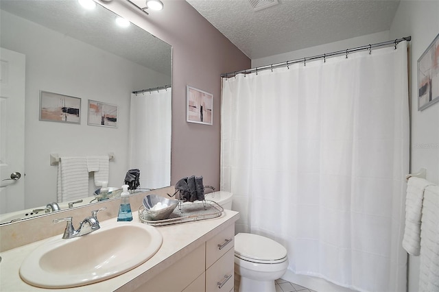 bathroom featuring tile patterned flooring, vanity, a textured ceiling, and toilet