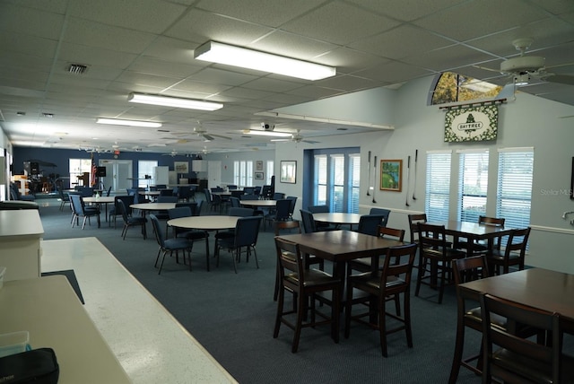 dining room with ceiling fan, a paneled ceiling, and carpet flooring