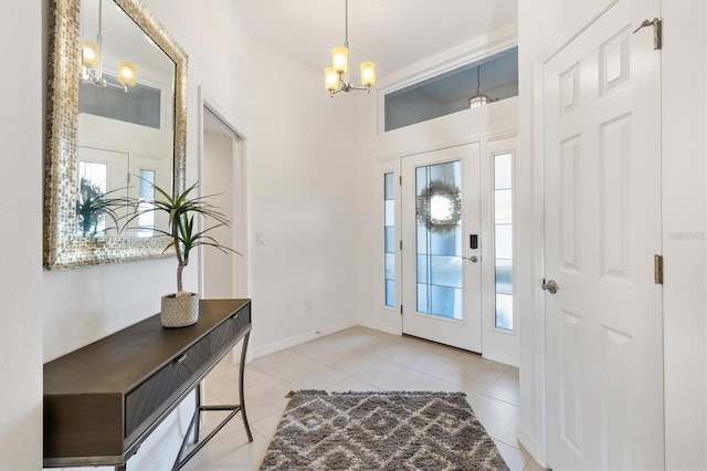 tiled entrance foyer featuring an inviting chandelier