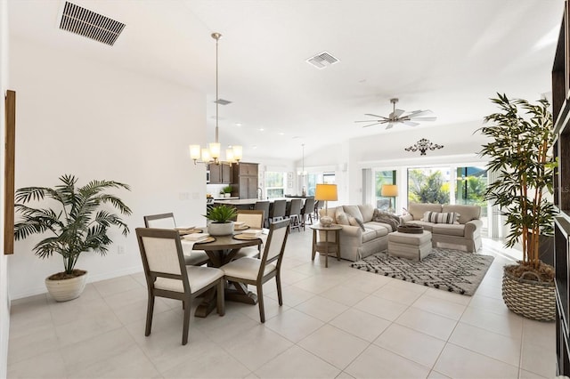 dining area featuring lofted ceiling, light tile patterned floors, and ceiling fan with notable chandelier