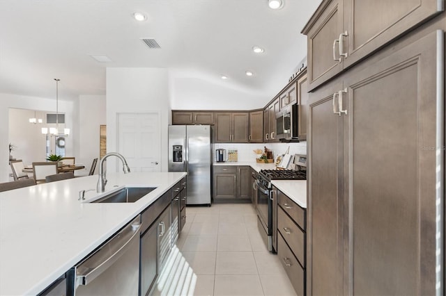 kitchen with sink, decorative light fixtures, light tile patterned floors, stainless steel appliances, and backsplash