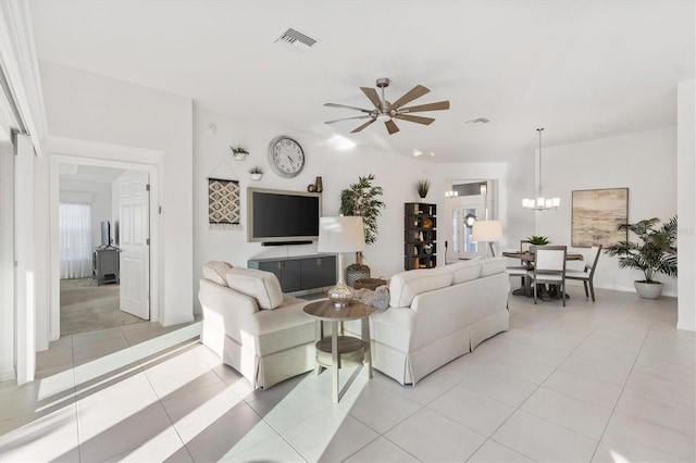 tiled living room with ceiling fan with notable chandelier