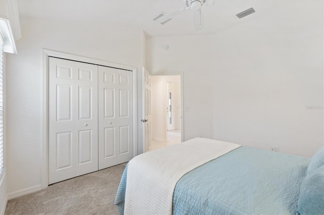 bedroom featuring ceiling fan, light colored carpet, and a closet