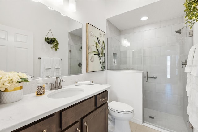 bathroom with tile patterned flooring, vanity, toilet, and walk in shower